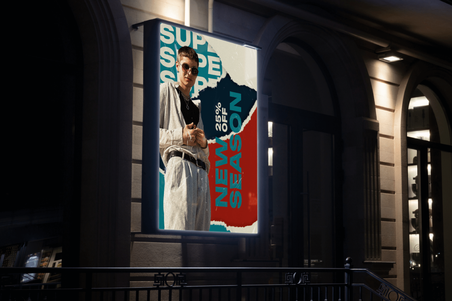 Wall-mounted illuminated poster lightbox on a building at night